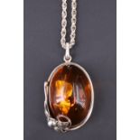 A contemporary sun spangled amber pendant necklace, having a 52 x 36 x 20 mm cabochon set on a white