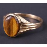 A 1970s tiger's eye signet ring, having a 9.5 x 8 mm vacant matrix set in a bark textured semi-bezel