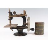 An early 20th Century toy hand-cranked Singer sewing machine together with an embossed double