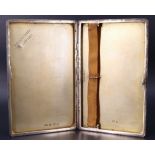 An Art Deco silver cigarette case, having canted corners with applied yellow metal and being