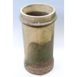 A cylindrical earthenware chimney pot, having a ribbed top, 32 x 61 cm