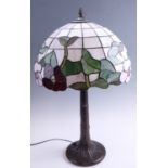 A late 20th Century Tiffany style table lamp, having a leaded glass shade on a patinated