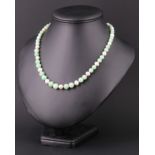 A contemporary jade and pearl necklace together with a white and green jade bracelet, both having