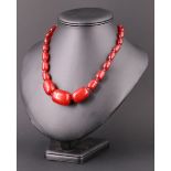 A vintage graduated cherry amber type Bakelite matinee length necklace, having a later white metal