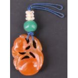 A Chinese carved peach jade pendant in the form of fruit, 3 cm x 2 cm