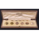 A cased set of six early 20th Century 9 ct gold waistcoat buttons, each circular with triple