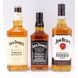 A bottle of Jack Daniel's Whiskey together with a bottle of Tennessee Honey and a bottle of Jim Beam