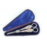 A cased pair of Edwardian silver plated grape scissors, case 20 x 8 x 2.5 cm