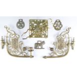 A Victorian cast brass trivet, having armorial decoration, a pair of ornate part candle holder