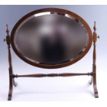 A Victorian oval mahogany swivel dressing / toilet mirror, having string inlay and a turned