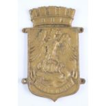 A cast brass plaque bearing a label inscribed "Rescued from a "brewed-up" (burnt out) tank in the