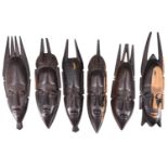 Six African carved hardwood wall masks, largest 26 cm