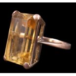 A 1970s citrine dress ring, the 17.5 x 11.5 mm emerald cut stone set on an open gallery between