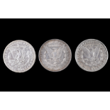 Three silver US "Morgan Dollar" coins, comprising an 1884 San Francisco, an 1885 New Orleans, and an