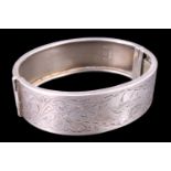 A 1930s silver bangle, bright cut decorated in depiction of a swallow gliding over a pond in a