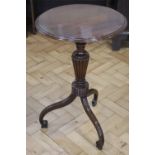 A Regency mahogany pedestal table, having a tapering reeded baluster column, scrolling legs, and