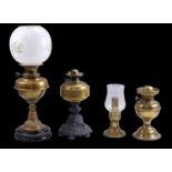 Three Victorian and later brass oil lamps and a candle lamp, tallest 54 cm, (a/f)