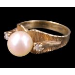 A 1970s pearl and white sapphire ring, the 7.5 mm pearl on a textured adorsed tapering band, between