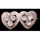 A late Victorian silver sentimental brooch of double open hearts, each having a three leaf clover,