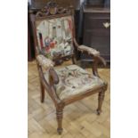 A William IV carved walnut open-arm elbow chair, having tapestry upholstery and a drop-in seat,