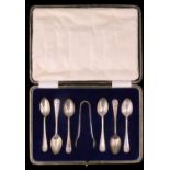 A cased set of six 1920s silver coffee spoons and sugar tongs, having anthemion decorated terminals,