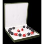 A contemporary coral and lava demi parure, the necklace having three large sections of red coral set