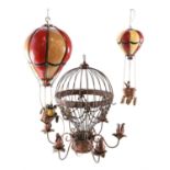 Two pendant hot air balloon ornaments together with a similar wrought metal pendant candle lamp,