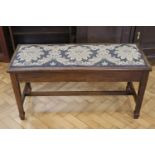 An Edwardian walnut piano bench, having a hinged upholstered seat, 99 x 39 x 52 cm