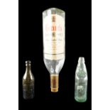 A large vacant Grant's Stand Fast glass whisky bottle together with a W Armstrong of Brampton codd-
