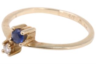 A contemporary blue and white sapphire finger ring, comprising a 2.75 mm blue brilliant and a 2 mm