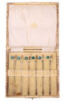 A cased set of enamelled silver cocktail sticks, the terminals bearing guilloché enamelled