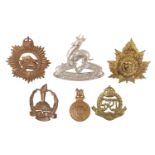 A small group of Dominions cap badges