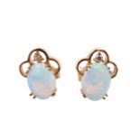 A pair of diamond and opal stud earrings, each having an 8 x 6 mm oval opal in a double claw