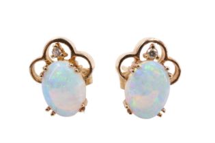 A pair of diamond and opal stud earrings, each having an 8 x 6 mm oval opal in a double claw