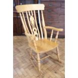 A late 20th Century beech wood rocking chair, having a pierced back-splat, 110 cm high