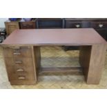A 1930s walnut desk, one end having a draw slide and four drawers, opposed by an adjustable
