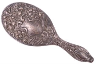 An early Edwardian silver hand mirror, having scrolling and floral repoussé decoration and a