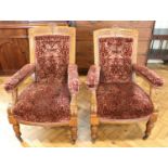 A pair of 19th Century Aesthetic influenced carved oak open arm salon armchairs, upholstered
