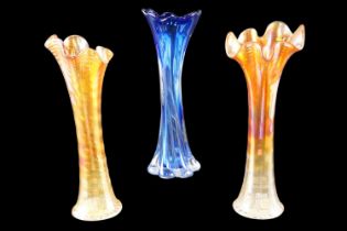 A pair of carnival glass wavy edged trumpet vases together with a similar cobalt glass vase, 30 cm