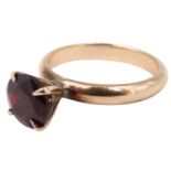 A late 20th Century garnet solitaire ring, having a 7.5 mm brilliant in a pronounced four claw