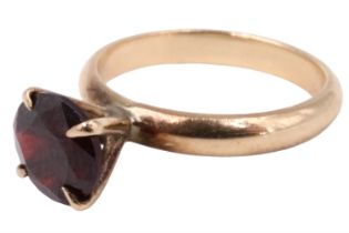 A late 20th Century garnet solitaire ring, having a 7.5 mm brilliant in a pronounced four claw