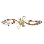 A Belle Epoque peridot and seed pearl brooch, having a 4.5 mm brilliant bezel-set between adorsed