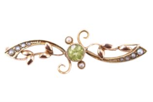 A Belle Epoque peridot and seed pearl brooch, having a 4.5 mm brilliant bezel-set between adorsed