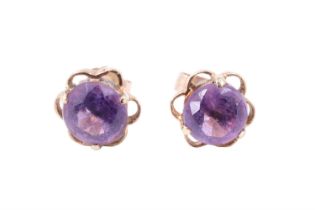 A pair of amethyst stud earrings, each having a 6.5 mm brilliant set on an openwork lobed back,