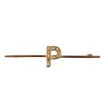 A yellow-metal bar brooch, faced with an initial "P" decorated with split seed pearls, marked "9