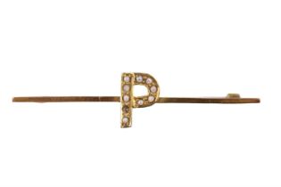 A yellow-metal bar brooch, faced with an initial "P" decorated with split seed pearls, marked "9