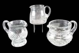 Three cut glass jugs, tallest 15 cm