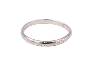 A late 20th Century precious white metal wedding band, of D section and having engraved