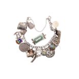 A vintage white metal charm bracelet together with a rolled £1 banknote charm