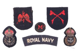 A small group of Royal Navy cloth insignia and two chief petty officer cap badges